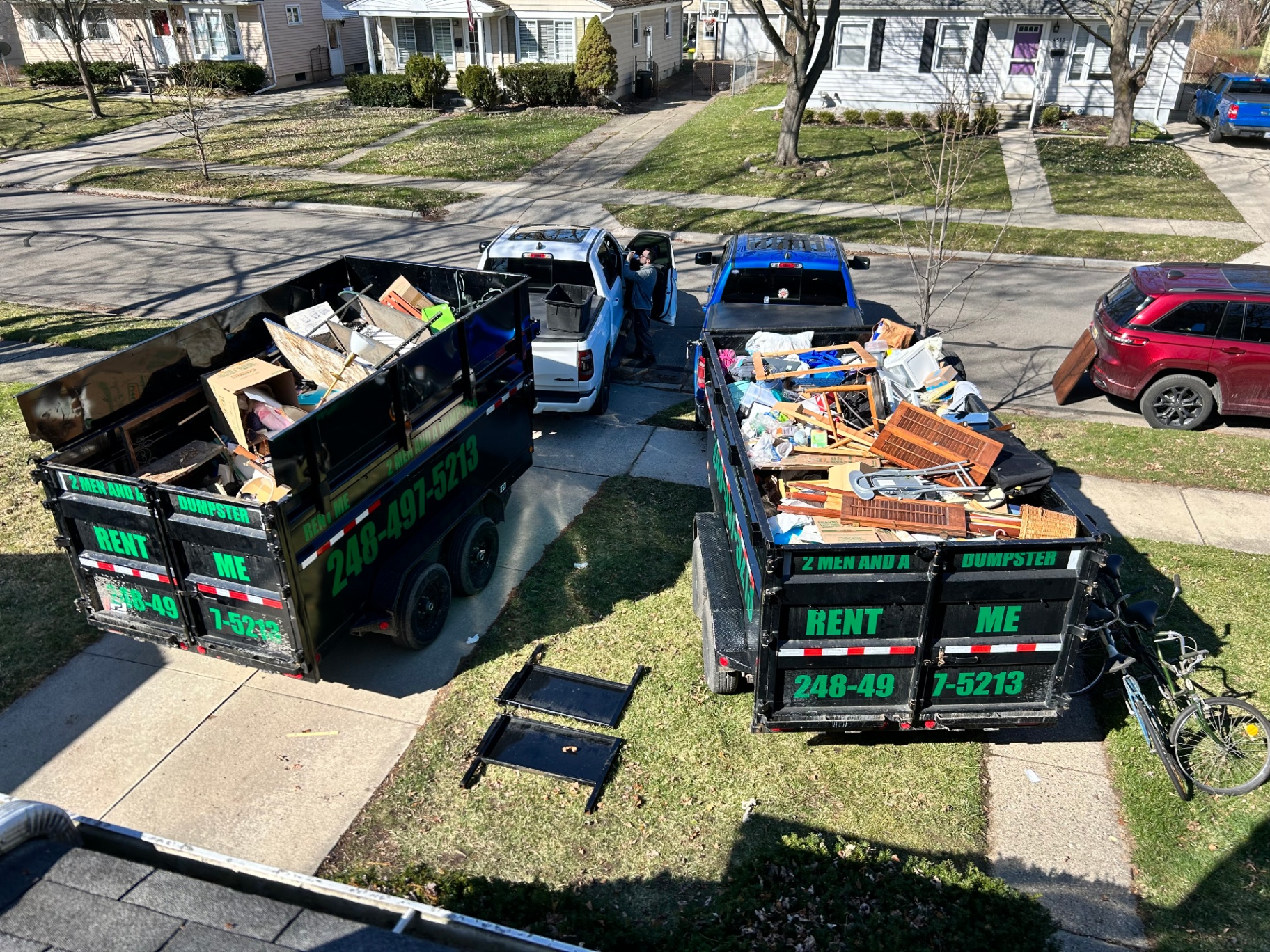 Green roll-off dumpster placed in a Metro Detroit driveway
